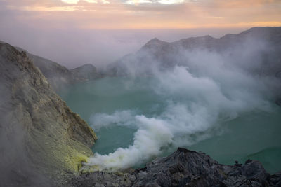 Smoke emitting from volcanic mountain against sky