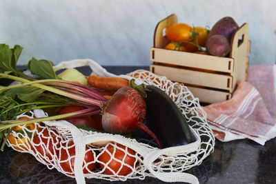 Vegetables in eco shopping bag and wooden box tomatoes, potatoes, eggplants, carrots,  beetroot