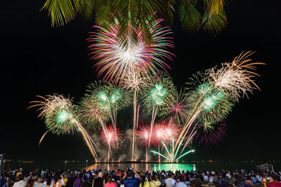 People watching firework display at night