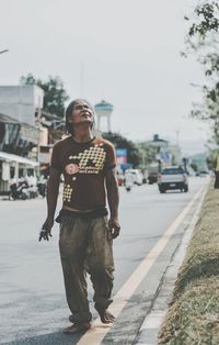 Full length of man standing on road in city