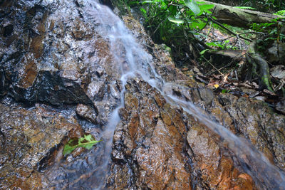High angle view of stream flowing through rocks