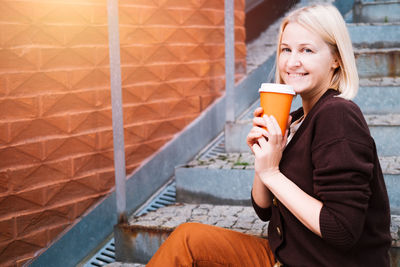 Portrait of young woman drinking coffee