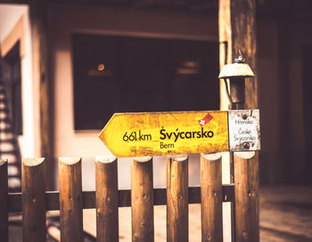 Close-up of information sign on wooden fence