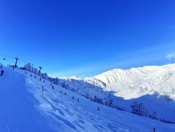 Scenic view of snowcapped mountains against blue sky