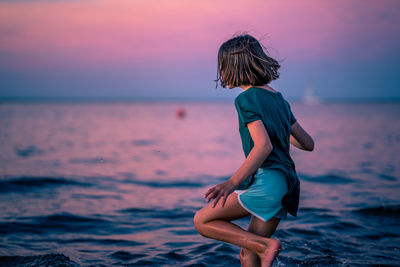 Rear view of woman on beach during sunset