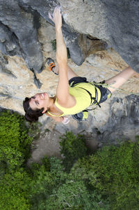 Portrait of confident woman climbing rock