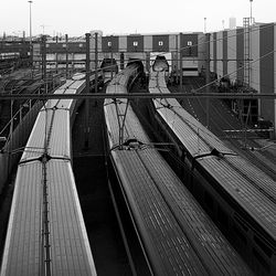 Train on railroad bridge in city against sky