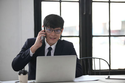 Portrait of mid adult man using laptop on table