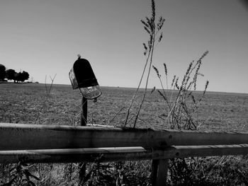 Fence on grassy field against sky