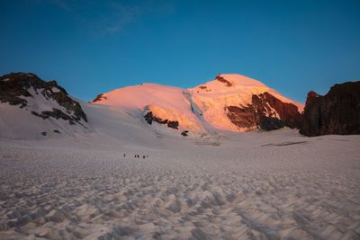 Scenic view of snow covered mountains against blue sky