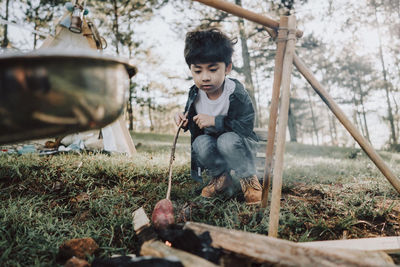 Full length of boy crouching on grass