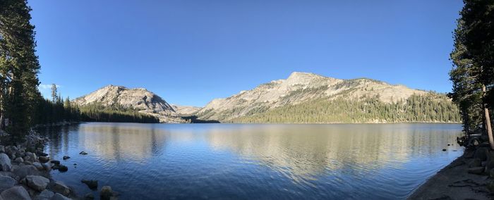 Scenic view of lake and mountains against clear blue sky