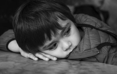 Close-up of cute boy lying on table