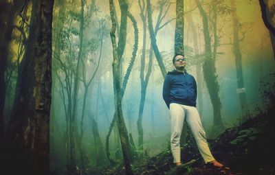 Portrait of man standing in forest