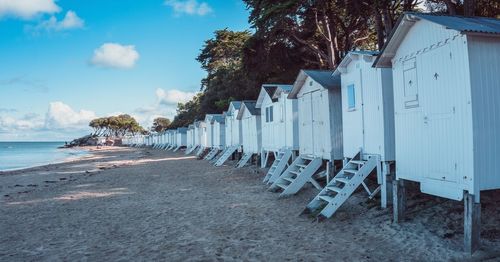 Beach huts by sea against sky