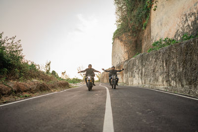 Rear view of man riding bicycle on road