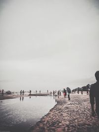 People on beach against sky