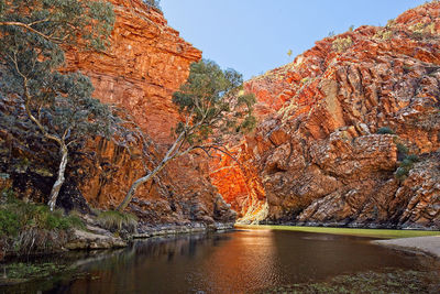 Orange cliffs and a waterhole in the australian outback