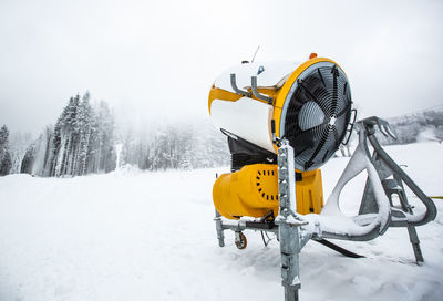 Ferris wheel on snow covered field against sky