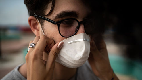 Close-up of man wearing flu mask embracing outdoors