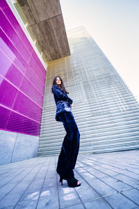 Full length of woman standing against wall