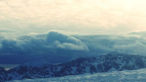 Scenic view of mountains against cloudy sky