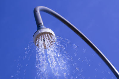 Low angle view of water drops on blue sky