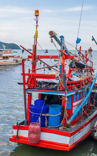 Fishing boat moored in sea against sky