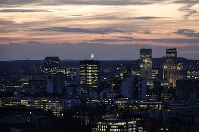 High angle view of illuminated buildings against cloudy sky