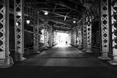 Rear view of man walking in illuminated building