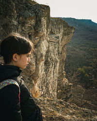 Rear view of woman standing on mountain against sky