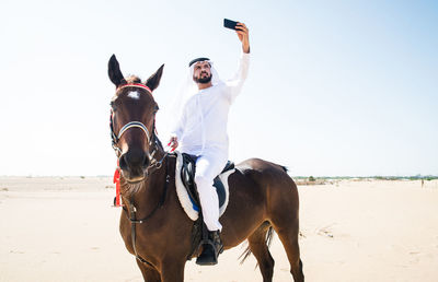 Man riding horse on beach