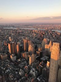 Aerial view of buildings in city against sky during sunset