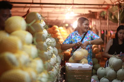 Woman buying cantaloupe at market