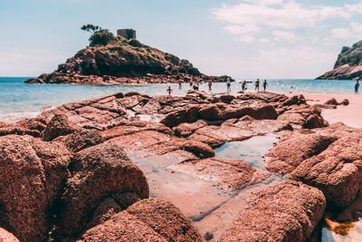 Rock formation on beach against sky