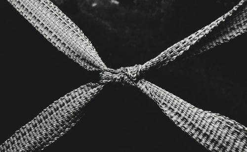Close-up of rope tied up against black background