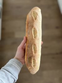 Hand holding a baguette bread