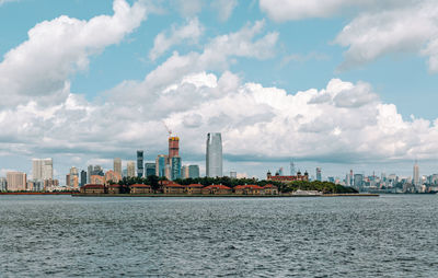 Scenic view of sea by buildings against sky