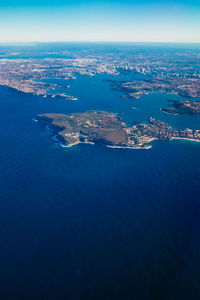 Aerial view of city by sea against sky