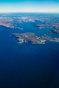 Aerial view of city by sea against sky