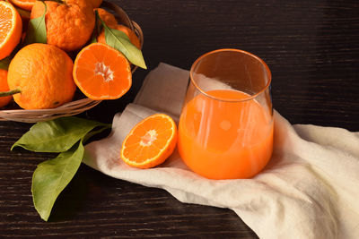 Close up of a glass of fresh and delicious tangerine juice with leaves