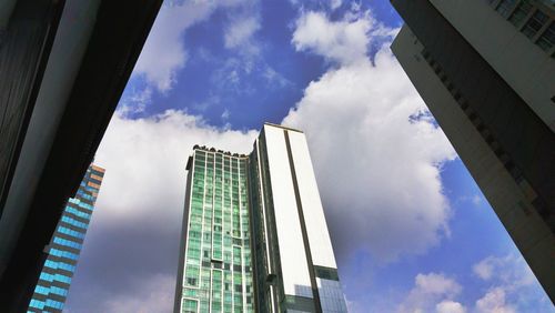 Low angle view of skyscrapers against blue sky