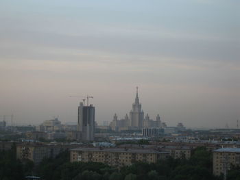 Buildings in city against sky during sunset