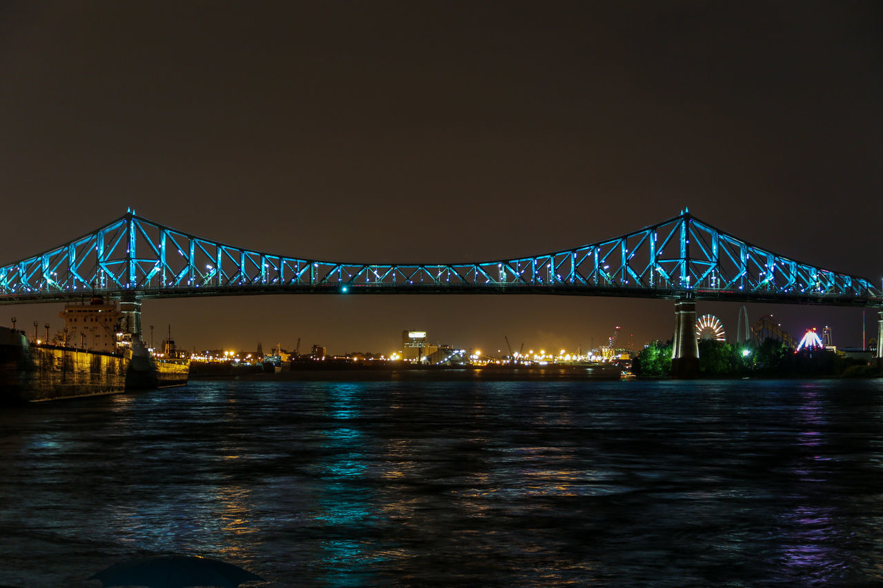 VIEW OF BRIDGE OVER RIVER AT NIGHT