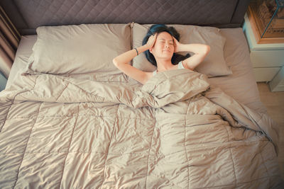 High angle view of mid adult woman sleeping on bed at home