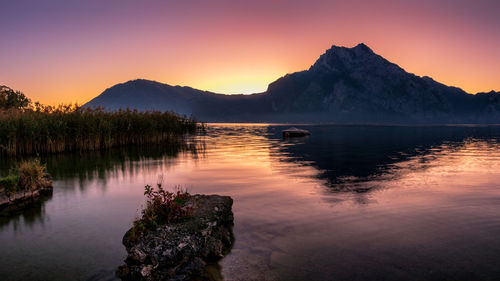 Scenic view of lake against mountains during sunset