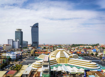 High angle view of city buildings against cloudy sky