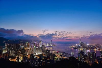 Illuminated cityscape against sky at night