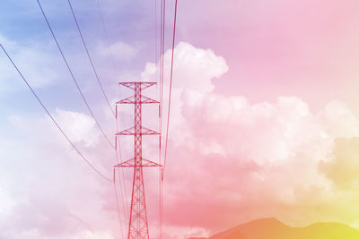 Low angle view of electricity pylon against sky during sunset