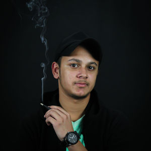 Portrait of a young man against black background